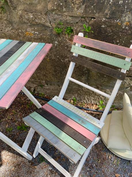 istock Multi colored shabby chic table and chair at the wall 1169417441