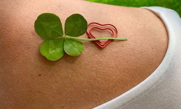 istock Four leaf clover and a double heart  on woman's shoulder 1169419837