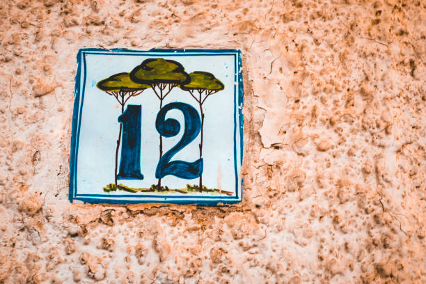 istock number 12 door sign on orange facade 1169419856