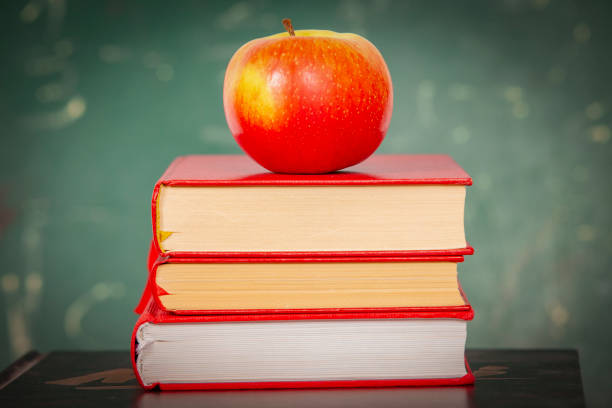 istock Apple lies on a staple of book 1169419934