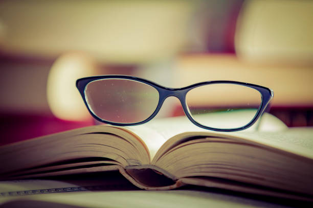 istock Glasses lies on red books 1169420187