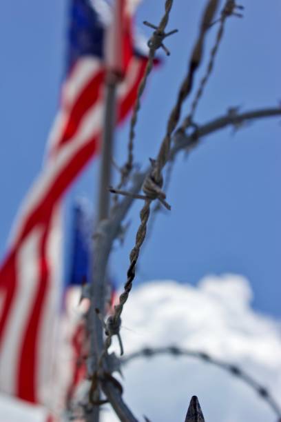 istock barbed wire with red, white and blue flags in background 1169420327