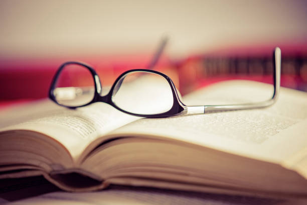 istock Glasses lies on red books 1169421584