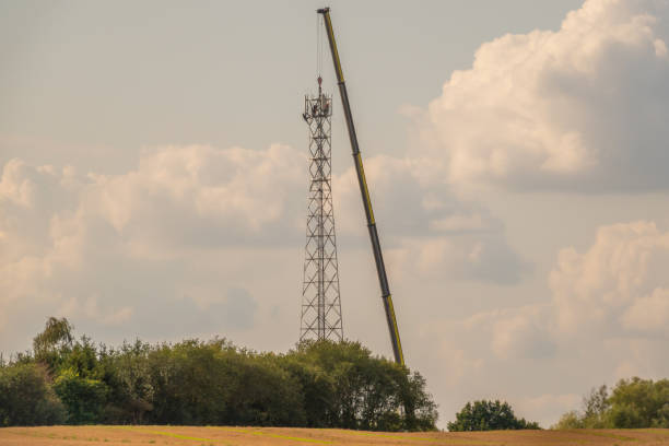 istock A 5G transmission tower is erected on a field with the help of a huge crane 1169422714