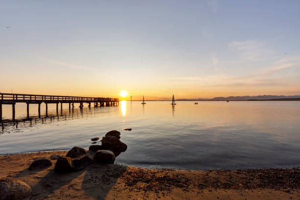Beach and pier at sunset, Surrey, BC, Canada Beach and pier at sunset, Surrey, BC, Canada surrey british columbia stock pictures, royalty-free photos & images