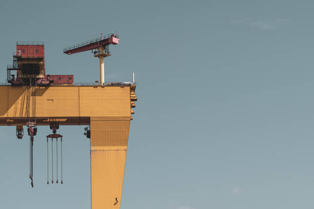 istock Yellow gantry crane towering over dry dock of a shipyard 1169427746