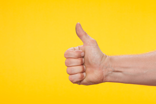 Thumb up on a yellow background