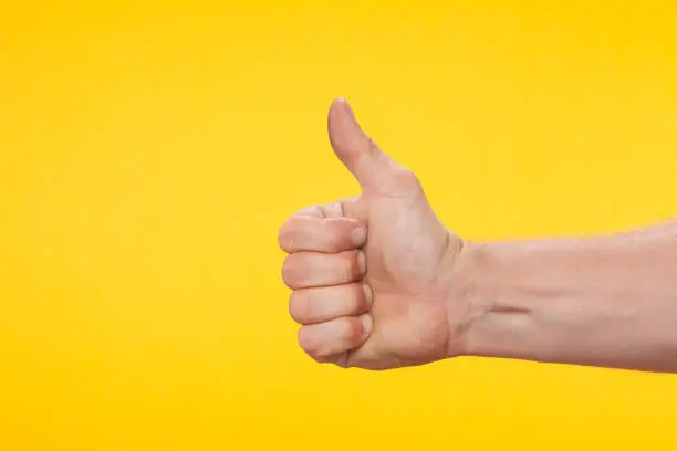 Photo of Thumb up on a yellow background