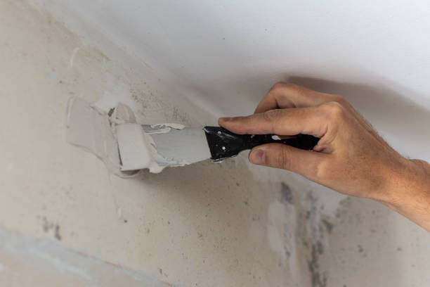 istock Worker's hand with a spatula and putty 1169430409