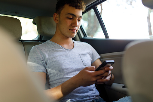 Passenger in car using smart phone