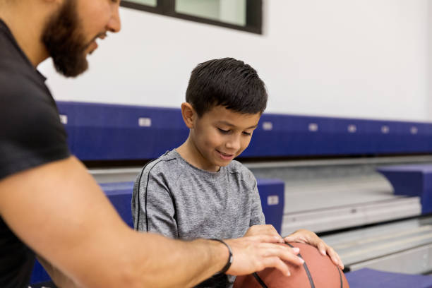 primer plano de papá e hijo hablando de baloncesto en el gimnasio - sport parent bleachers family fotografías e imágenes de stock