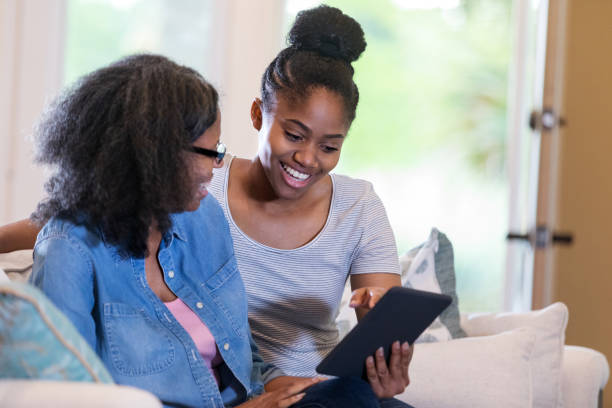 istock Smiling young woman shows her mom something on tablet 1169431811