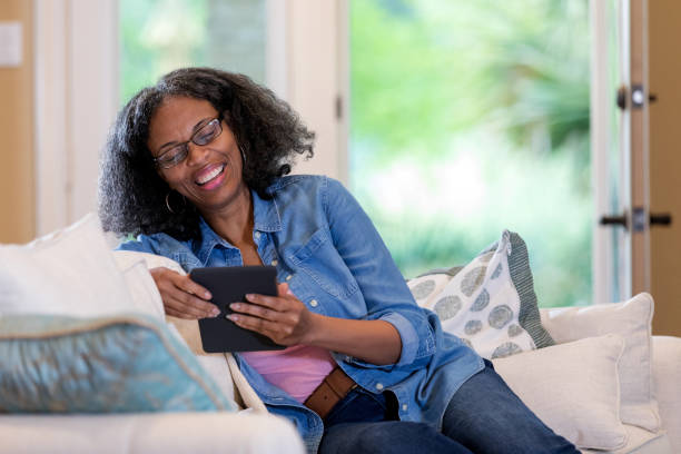 istock Smiling woman reading digital tablet 1169431845