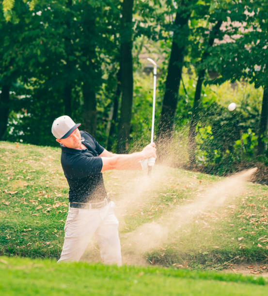 istock A golf pro with a perfect bunker shot. 1169432840