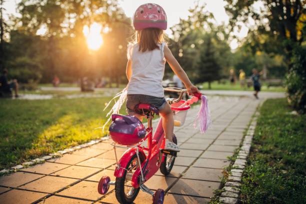Little girl learning to drive a bicycle in public park