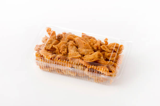 istock Crispy Fried Chicken Skin in a plastic container on white background 1169438410