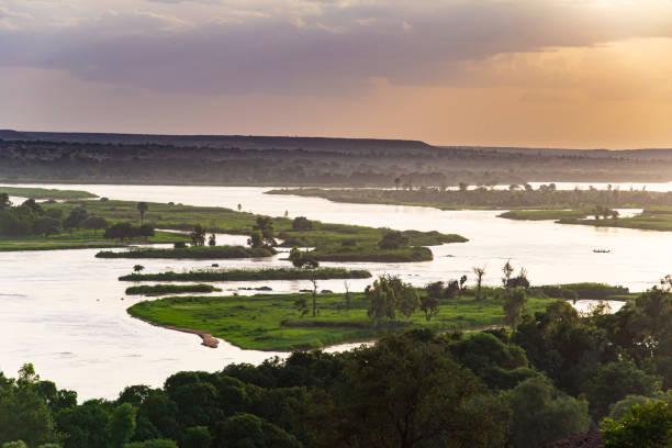 evening pastel-coloured sky over meanders, islands and green shores of niger river seen from higher ground during outside niamey capital of niger during humid season in summer - niger river imagens e fotografias de stock