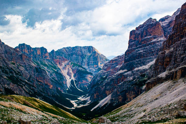walking on the dolomitic paths protected by the unesco attracts extraordinary panoramas between peaks of rock, white clouds on blue skies, hiking among the rocks near Cortina D'ampezzo, Italy