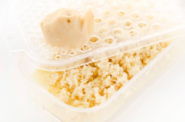 istock Grated ginger root in Grater on white background 1169442085