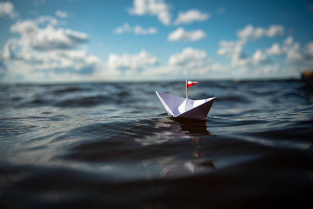 istock Paper ship in big waves 1169444533