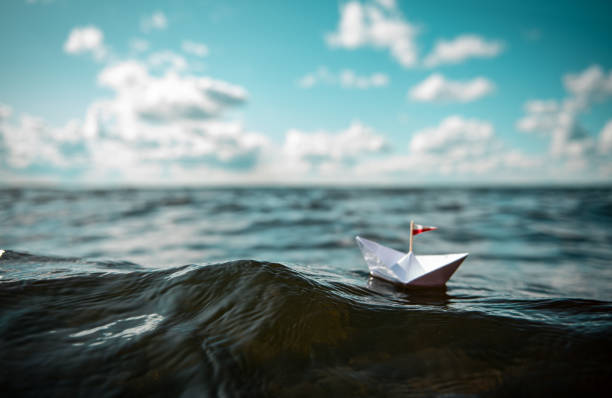 istock Paper ship in big waves 1169444548
