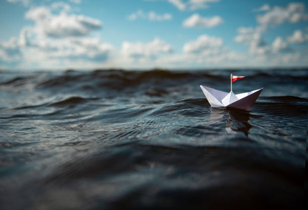 istock Paper ship in big waves 1169444594