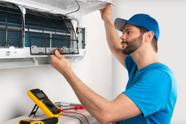 le service d'installation fixe l'entretien de réparation d'une unité intérieure de climatiseur, par le travailleur technican cryogéniste vérifiant le filtre d'air dans la casquette bleue de base-ball de chemise - electrician repairman men maintenance engineer photos et images de collection