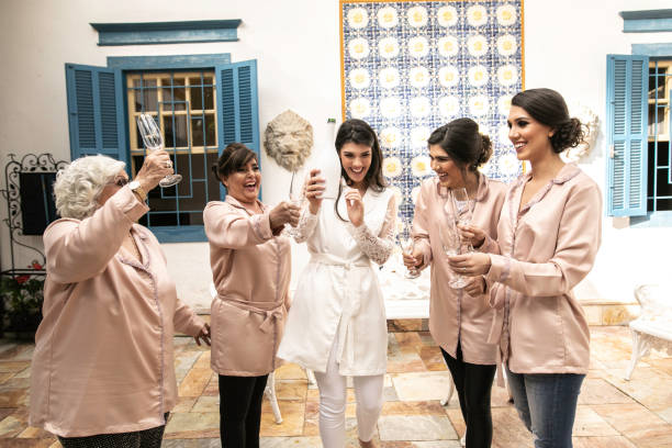 istock Bride open a bottle of champagne with bridesmaid 1169458935