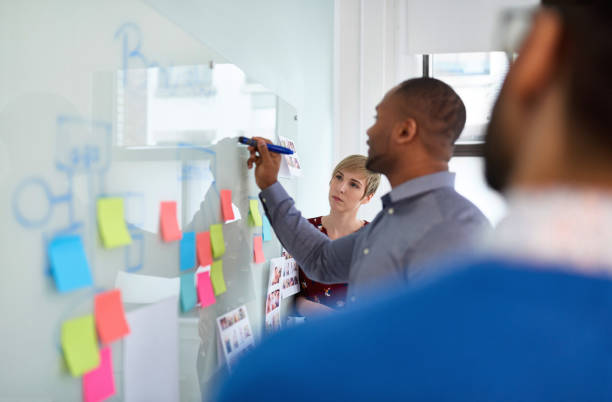 diverso equipo de colaboradores millennials creativos en una startup de estrategias de lluvia de ideas - planning adhesive note business office fotografías e imágenes de stock