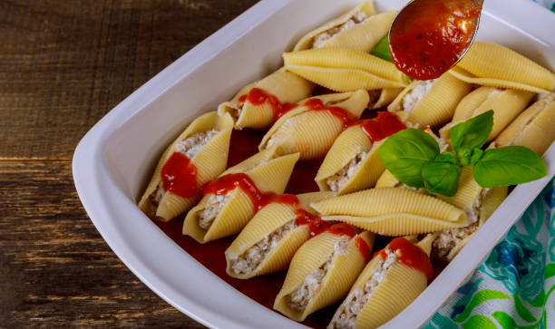 Pasta shells stuffed with beef, ricotta cheese with tomato sauce. Pasta shells stuffed with beef, ricotta cheese with tomato sauce in oven bowl. large pasta pot stock pictures, royalty-free photos & images