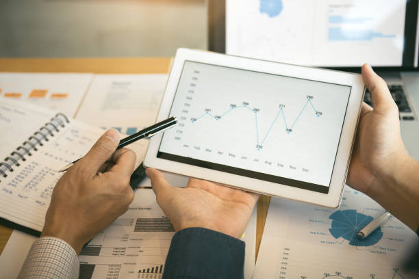istock Business partnership coworkers analysis cost work progress and using a tablet to graph company financial budget report and planning for future in office room. 1169476164