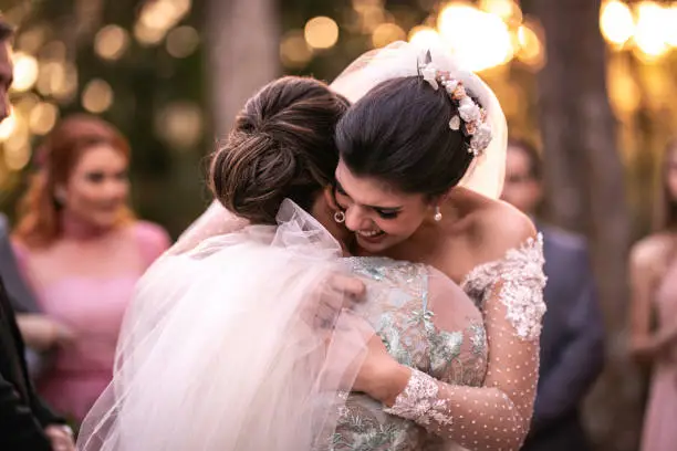 Emotional bride being congratulated by the wedding guests