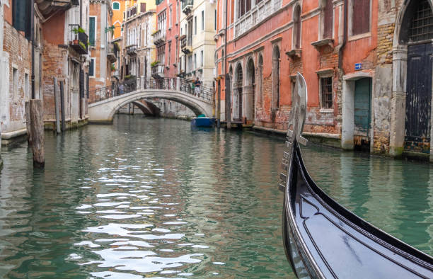 istock Gondola navigating a canal at Venice 1169478220