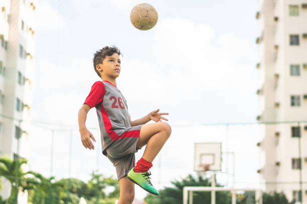 istock Boy juggling a ball with on his knee 1169479276