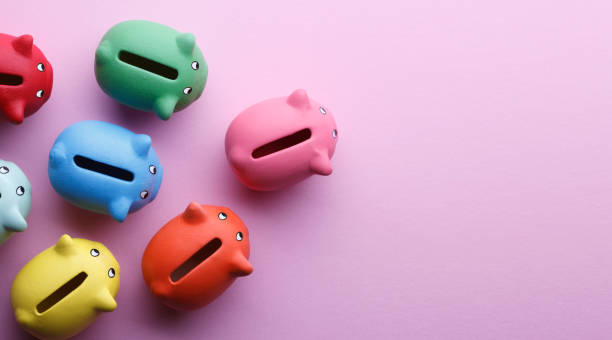 Colorful Piggy Banks Top view of piggy banks over pink background. piggy bank finance currency savings stock pictures, royalty-free photos & images