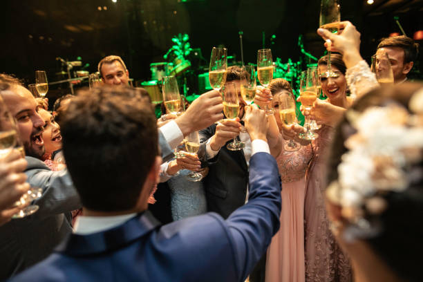 istock Bride, groom and wedding guests making a toast 1169481174