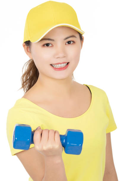 Beautiful Chinese American woman working out using dumbbell weights isolated on a white background