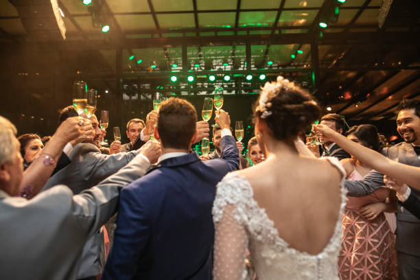 Bride, groom and wedding guests making a toast Bride, groom and wedding guests making a toast wedding party stock pictures, royalty-free photos & images