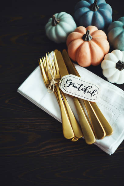 istock Thanksgiving Table Setting Background with Pumpkins and Gold Cutlery 1169482309