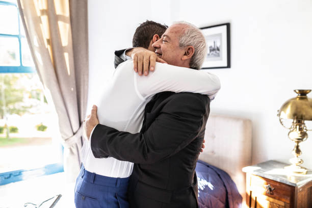 Groom and father embracing before the wedding