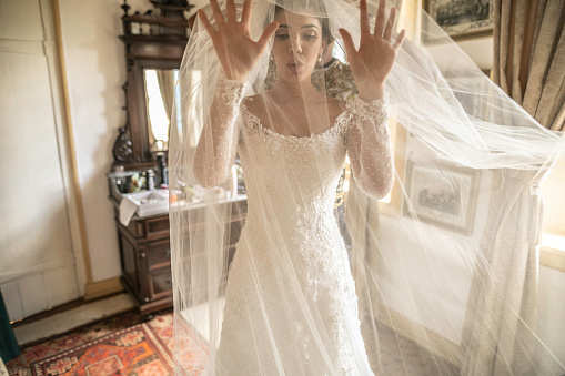 Anxious bride wearing the veil before wedding ceremony