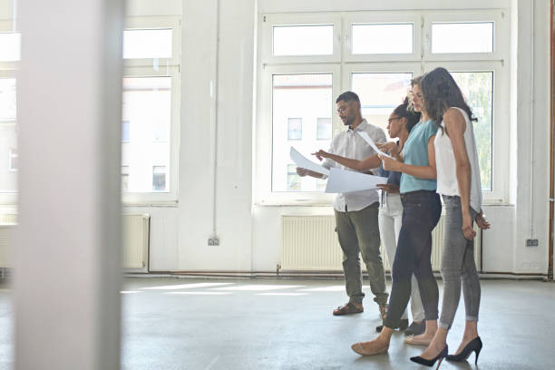 istock Young Business Owners Evaluating Plans for New Office Space 1169491064