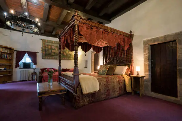 The laird's bedroom with a four poster bed and tapestries in a medieval castle tower, Castle Levan, Gourock, Scotland, UK, Europe