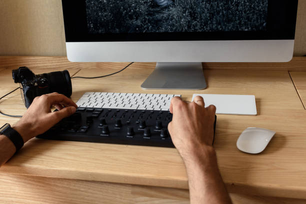 istock Photographer processes photos on a computer at a table in a room 1169499227