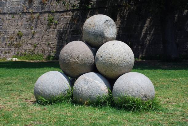 A pile of old stone cannonballs in the drained moat surrounding the medieval wall of Rhodes Old Town on the Greek island of Rhodes.
