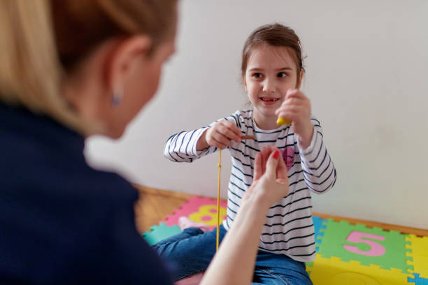 istock Girl practicing fine motor skills looking at her tutor 1169502185