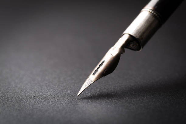 istock Old fountain pen on a black textured background 1169502288