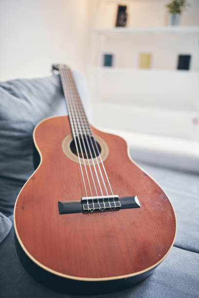 istock Acoustic guitar on a living room couch / sofa. 1169503036