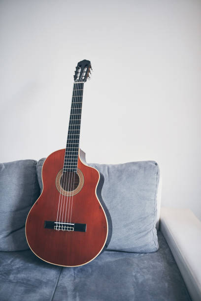 istock Acoustic guitar on a living room couch / sofa. 1169503044