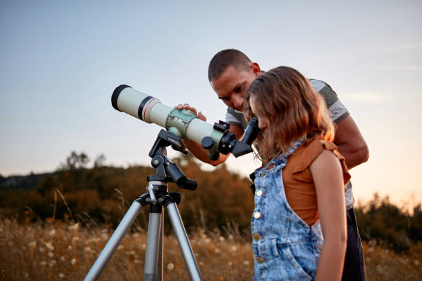 istock Father and daughter observing the sky with a telescope. 1169503155